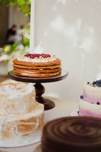 Delicious assortment of gourmet cakes displayed on a table at an outdoor event, featuring layered and topped desserts.
