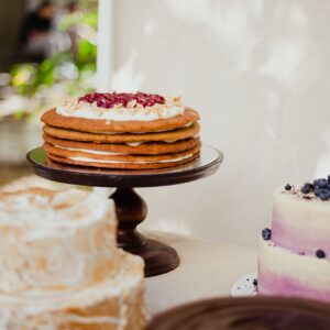 Delicious assortment of gourmet cakes displayed on a table at an outdoor event, featuring layered and topped desserts.